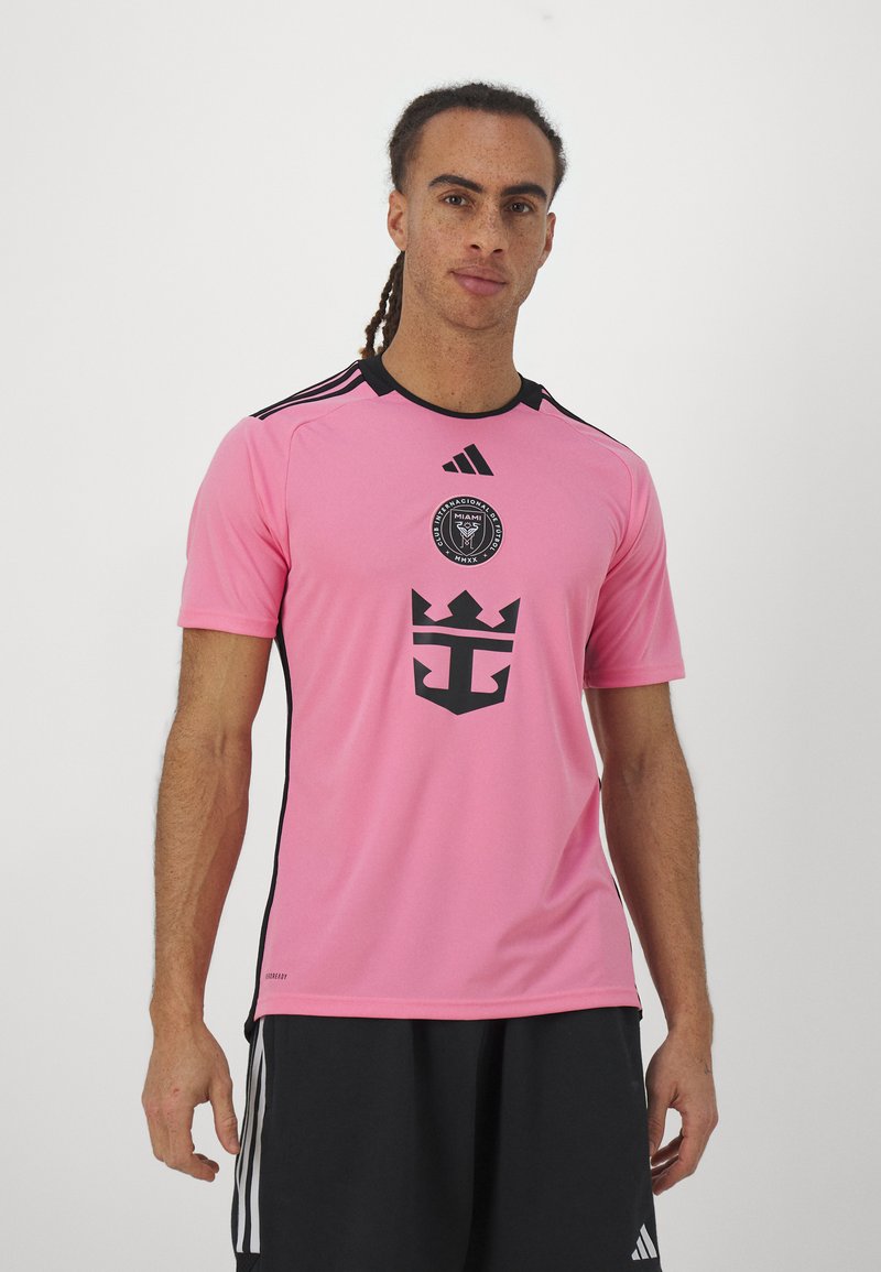 Maglia da calcio rosa a manica corta con accenti neri, dotata di un logo circolare e un design a corona sul davanti. Realizzata in tessuto leggero.