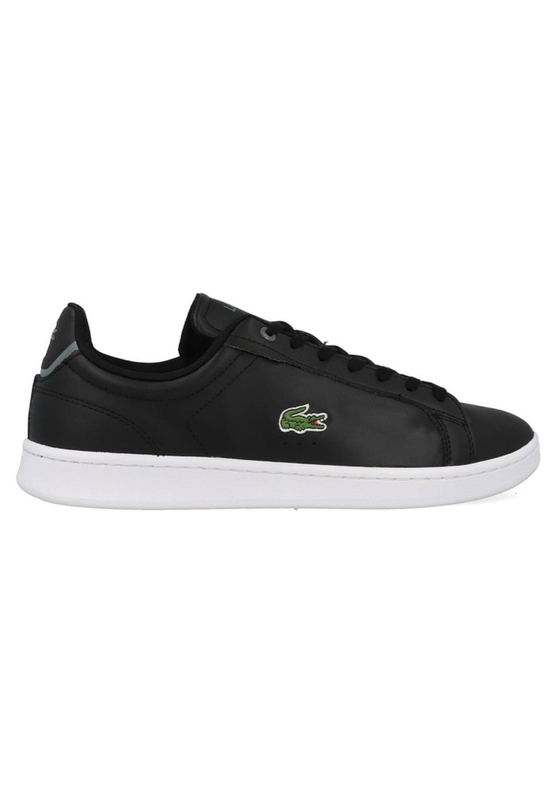 Baskets en cuir noir avec une texture lisse, semelle en caoutchouc blanche et logo crocodile vert Lacoste sur le côté. Lacets plats et design minimaliste.
