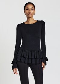 Top nero a maniche lunghe con scollo tondo, tessuto testurizzato e orlo a strati con volant svasati. Silhouette aderente.