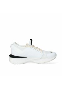 Scarpe da ginnastica bianche con tomaia in rete, accentuazione nera sul tallone, lacci crema e una suola spessa bianca. Presentano un design elegante e moderno.