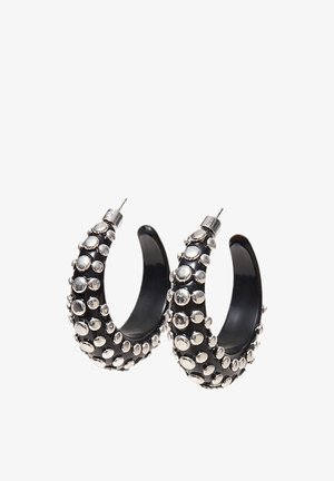 Orecchini a cerchio a forma di mezzaluna nera con borchie circolari in argento rialzate che coprono la superficie esterna e chiusure a perno in metallo.