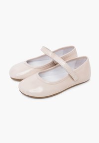 Světlé růžové baletní boty z lakované kůže s kulatou špičkou a plochou podrážkou, vybavené páskem přes nárt pro bezpečné uchycení.