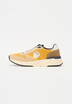 Sneakers with a yellow textile upper, beige suede accents, and black rubber sole. Features white logo patch and navy detailing on the collar.