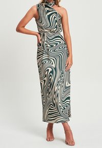 Vestido maxi sin mangas, de un solo hombro, en patrones en espiral verde y beige, elaborado con una tela suave, con cintura ajustada y abertura lateral.