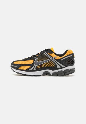 Black and orange running shoe with mesh upper, reflective silver Nike swoosh, cushioned sole, and black rubber outsole.