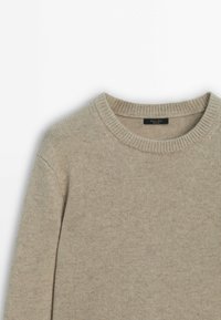 Pull beige en laine à col rond avec col côtelé et manches longues, étalé à plat sur un fond blanc.