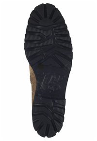 Suola di una sneaker robusta con un profondo motivo di battistrada, realizzata in gomma nera con texture scanalate e una sezione superiore in suede color tan visibile.