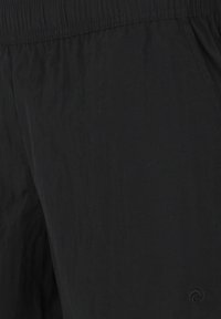 Zwarte lichte shorts van gestructureerde stof met een elastische tailleband en zijzakken. Heeft een logo-accent nabij de zoom.