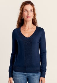 Marineblaues Strick-Sweatshirt mit V-Ausschnitt, ausgestattet mit einem strukturierten Mittelteil und glatten Ärmeln. Weiches Material mit gerippten Bündchen und Saum.