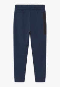 Marina joggers med elastisk midja, dragkedjefickor på sidan, avsmalnande ben och en mjuk textur. Har sömmar med paneldetaljer.