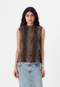 Top senza maniche con stampa leopardata e texture plissettata, in varie tonalità di marrone e nero, abbinato a una gonna di jeans azzurro chiaro.