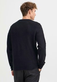 Sort, strikket genser med rund hals, lange ermer og ribbede mansjetter. Myk tekstur, ensfarget og uformell design.