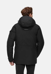 Zwarte geïsoleerde jas met een capuchon, met een soepele textuur, verstelbare manchetten en een logo op de bovenrug.
