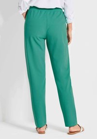 Grüne, gerade geschnittene Hosen aus glattem Stoff mit einem elastischen Bund. Merkmale ein schlichtes Design und eine verkürzte Länge.