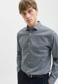 Cămașă cu nasturi, cu un model geometric albastru închis și alb, mâneci lungi, guler ascuțit și material din bumbac fin. Dispune de nasturi albi și un croi slim.