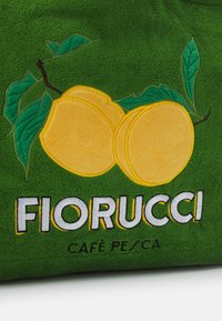 Grön textil med gul persiko-broderi och gröna löv. "FIORUCCI" i vitt, med "CAFÉ PESC A" nedanför i mindre teckensnitt.