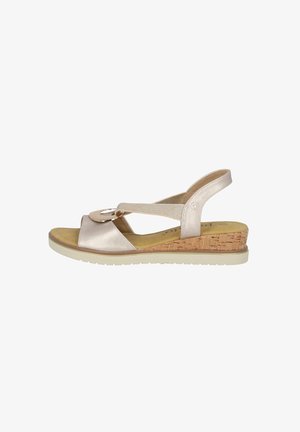 Wedge sandal med en korkhæl, metallic gul læderoverdel, åbent tådesign og justerbar ankelrem med dekorativt cirkulært hardware.
