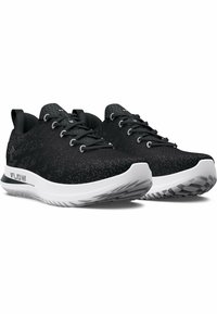 Chaussures de sport noires avec une tige texturée, un bout rond et une semelle blanche avec un motif de bande de roulement. Inclus des lacets noirs et un logo.