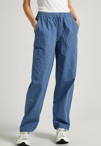 Pantaloni cargo blu con vita elastica, chiusura con coulisse, due tasche laterali, vestibilità ampia e polsini elasticizzati. Realizzati in tessuto leggero.