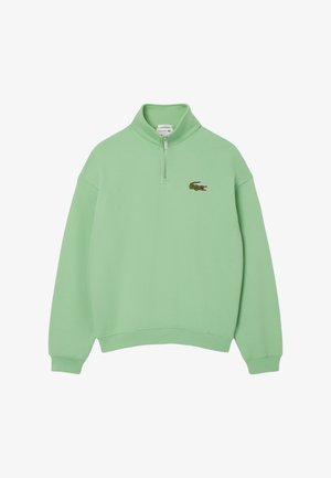Hellgrüner Langarm-Pullover mit kurzem Frontreißverschluss und kleinem, gesticktem Krokodil-Logo auf der linken Brust.