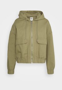 Olive green cropped zip-up jacket, featuring a hood, two front pockets, and elastic cuffs. Material appears textured and durable.