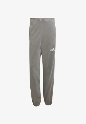 Szare spodnie sportowe z miękkiego materiału, z elastycznym pasem i zwężanymi mankietami. Posiadają białe logo Adidas na lewej udzie.