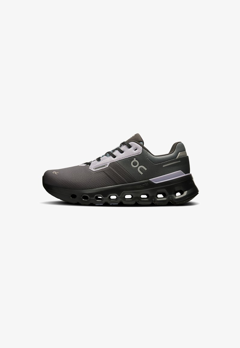 Gray athletic shoe with a textured mesh upper, lace-up design, prominent black sole with cutouts, and logo accent on side.