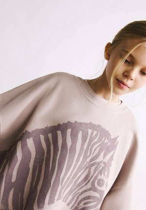Sweatshirt beige surdimensionné avec un grand imprimé zèbre en marron foncé, col rond, et coupe décontractée. Tissu en coton lisse.