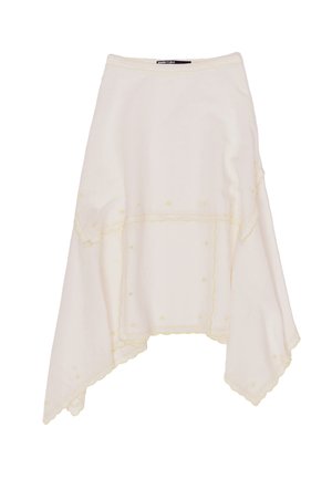 White asymmetrical skirt with yellow embroidery, textured fabric, and scalloped edges. Features decorative stitching and dotted accents.