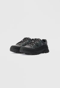 Ein Paar schwarze und dunkelgraue, niedrig geschnittene Wanderschuhe mit dicken Sohlen und Schnürdesign auf einem weißen Hintergrund.