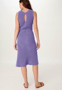 Lila Strickkleid mit ärmellosem Design, das ein Schlüssellochdetail im Rücken und einen ausgestellten Saum aufweist. Glatte Textur und mittellange Passform.