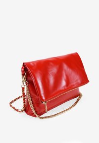 Bolso de mano de cuero rojo con cierre de cremallera, diseño con solapa y correa de cadena dorada. Textura suave con un compartimento espacioso.