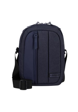 Borsa a tracolla blu navy in tessuto testurizzato, con tasca frontale con zip, tracolla regolabile e patch con logo. Design rettangolare compatto.