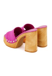 Roze suède open-teen klompen met een houten blokhak, voorzien van gouden studs langs de voorkant en een zachte leren inlegzool.