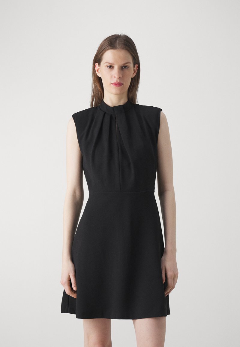 Black sleeveless dress with a high collar, featuring pleats at the front and a flared skirt. Made from a smooth, lightweight fabric.