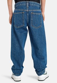 Blaue Jeans aus Denim mit lockerer Passform, hoher Taille und aufgerollten Säumen. Mit zwei Gesäßtaschen und kontrastierenden Nähten.