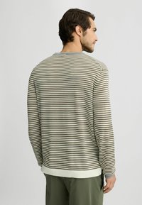 Gestreiftes Langarmoberteil mit lockerer Passform. Mit horizontalen hellbraunen und beige Streifen, gerippten Bündchen und einem einfarbigen hellgrauen Kragen.