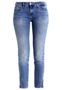 Jeans de mezclilla azul ajustados con un lavado claro, que cuentan con bolsillos frontales, un detalle de cremallera en los puños y trabillas para cinturón. Diseño clásico de cinco bolsillos.