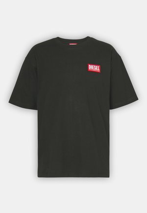 T-shirt in cotone nero con collo a giro e maniche corte. Presenta un logo rettangolare rosso con il testo "DIESEL" sul lato sinistro del petto.
