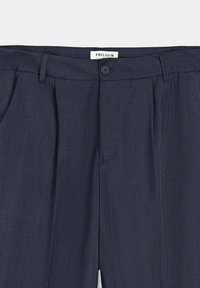Pantalons plissés bleu marine avec une texture lisse, dotés d'une fermeture à bouton et d'une étiquette « FRILIVIN » à la taille.