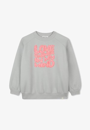 Sweat-shirt gris clair arborant le texte "L'AMOUR RAYONNE DANS MA TÊTE" en lettres roses scintillantes, conçu avec une coupe décontractée et des poignets côtelés.