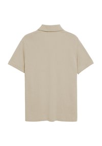 Polo beige realizzato in tessuto morbido, con colletto classico, maniche corte e vestibilità ampia, caratterizzato da una texture liscia e dettagli minimi.