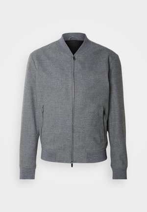 Gray bomber jacket with a structured fit, ribbed cuffs and hem, two zippered side pockets, and a smooth finish. Features a stand collar.