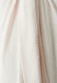 Teksturerana tkanina v mehki roza barvi, ki ima ponavljajoč se vzorec palmovih listov. Material se zdi lahek in rahlo sijoč.