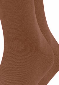 Braune Socken mit einer gerippten Textur, ausgestattet mit einem glatten, nahtlosen Design und passgenauer Form, in einer Nahaufnahme dargestellt.