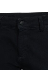 Czarne dżinsy z zapięciem na guzik, szlufkami na pasek i gładką fakturą. Posiada subtelny wzór w jodełkę.