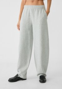 Lys grå, løstsiddende sweatpants lavet af blødt stof med elastisk talje, sidelommer og et lige ben design.