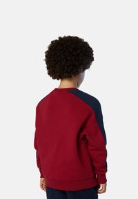 Felpa rossa e blu navy con colletto tondo, maniche lunghe e polsini a coste. Presenta un design a blocchi di colore con una finitura testurizzata.