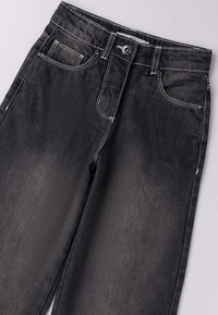 Jeans in denim nero con un design classico a cinque tasche, caratterizzati da cuciture bianche, chiusura con bottoni e una leggera scoloritura sulle gambe.