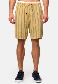 Shorts à rayures jaune clair en tissu texturé, dotés d'une taille élastique avec cordon de serrage et de poches latérales.